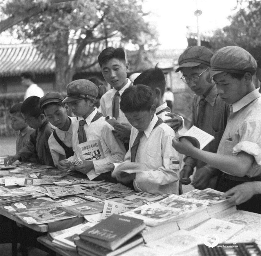 1951年，北京市中山公园内新华书店售书亭为了庆祝六一国际儿童节，为儿童准备了大批儿童读物。图为儿童们在选购以九折出售的儿童读物。