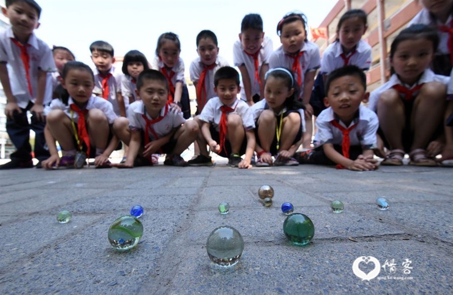 2017年5月31日，河北省邯郸市丛台小学的学生玩弹玻璃球游戏。