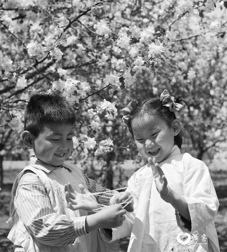 1962年5月，原哈尔滨亚麻纺织厂幼儿园的孩子在做翻花绳游戏。